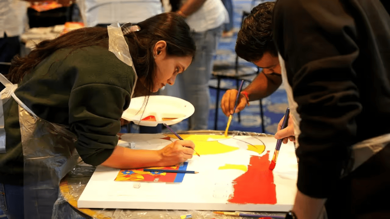 Two guests painting a large canvas together with acrylics at Gilgamesh for Creative Arts, Jabal Al-Lweibdeh, Amman