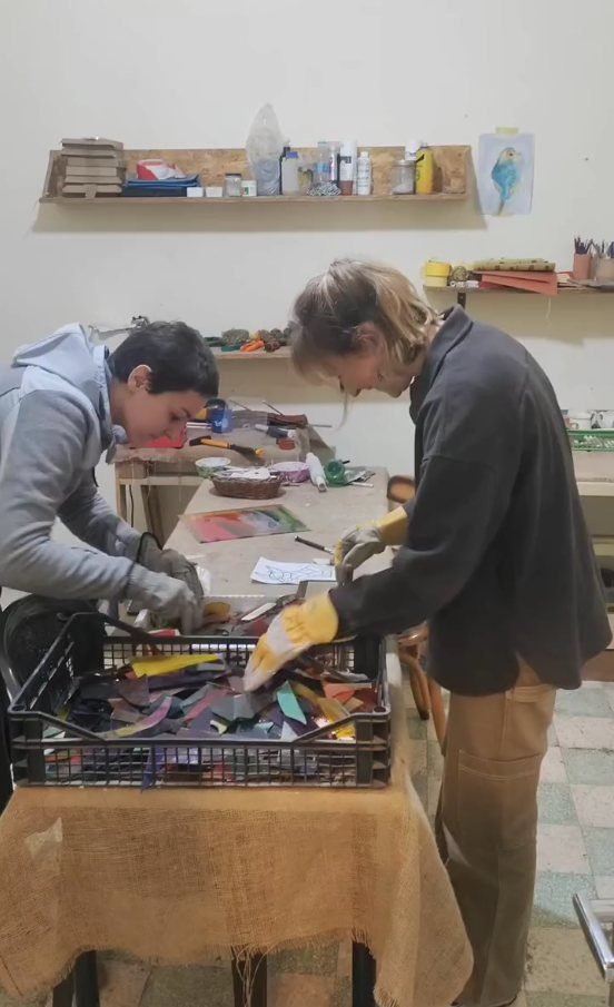 Participants choosing coloured glass sheets from the rack at the stained glass workshop in Jabal Al-Lweibdeh